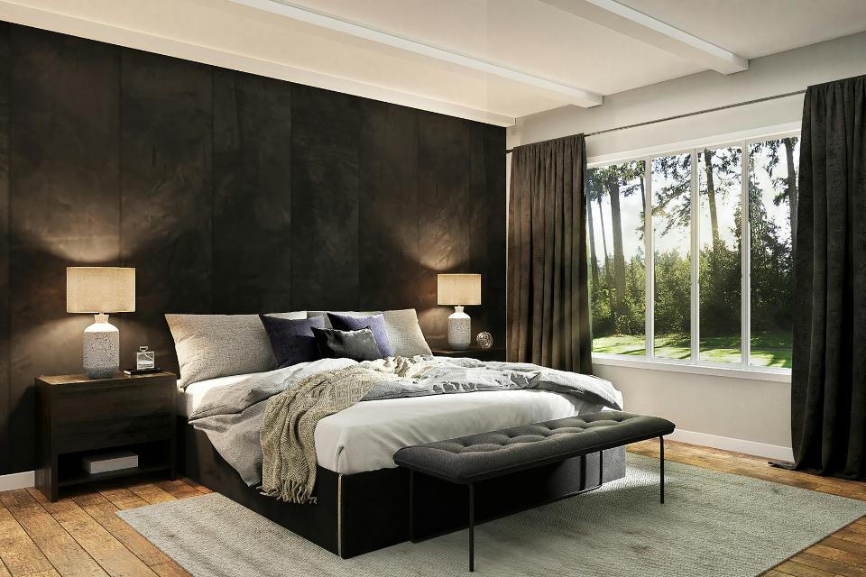 cozy bedroom with wood flooring and grey area rug with black accent wall and black furniture.